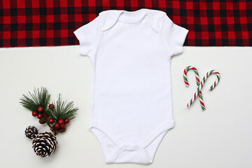 Baby onesie flat lay on a white Christmas background. Baby bodysuit mockup. Copy space for your design here. Top view. Flat Lay.