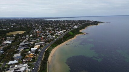 Fototapeta premium aerial view of the city and beach next to Australian bay area with patches of corals underwater