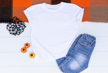 White kids t-shirt with jean and pumpkins on a white background. Blank halloween t shirt with space...