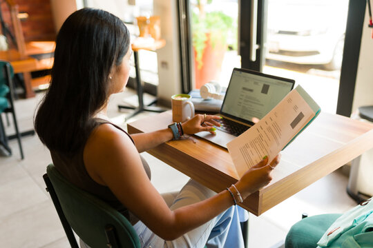 Smart woman at a coffee shop applying for a new job with her resume