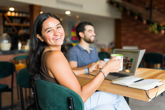 Cheerful woman and man doing remote work at the coffee shop