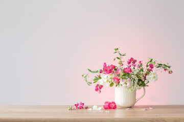 summer flowers in ceramic cup on light background