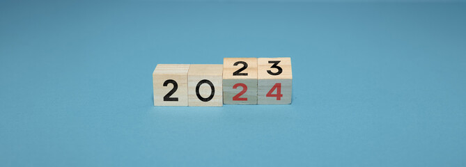 Cube turns from 2023 to 2024 on light blue background new year concept