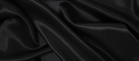 Smooth elegant black silk or satin luxury cloth texture as abstract background. Luxurious background design