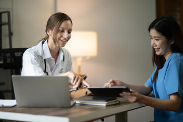 Fototapeta premium female doctor consulting with a female nurse at the clinic at the hospital