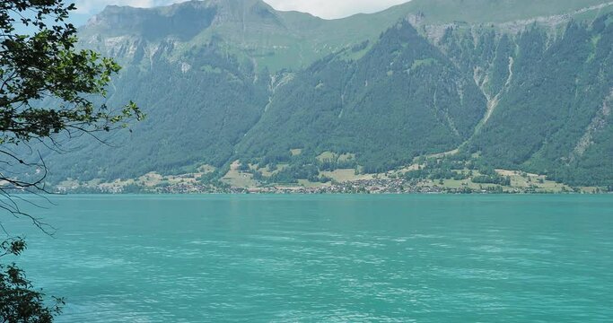 Lake Brienz in Swiss Alps. Iseltwald-Giessbach trail. One of the most beautiful shore view of the blue-green lake and  Emmental Alps peak above the village of Niederried 