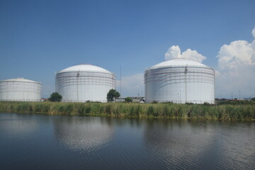 Obraz premium Giant tank for oil storage, which is on the edge of the river