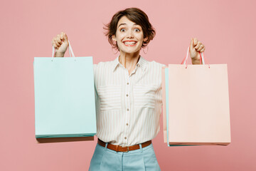 Young excited exultant woman wear casual clothes hold shopping paper package bags look camera show...