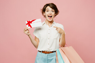 Young shocked fun woman wear casual clothes hold shopping paper package bags, gift certificate...