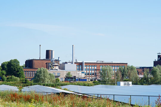 Cityscape of a industrial area of Arnhem with solar panels in the fthe foreground and a clear blue sky in the Netherlands