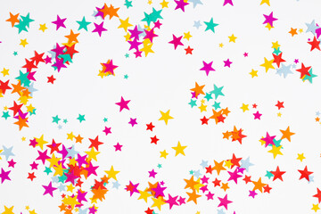 Festive background. Flat lay, top view of colorful  stars, stars on white background. Decoration party, birthday, anniversary, Christmas, New Year celebration concept.