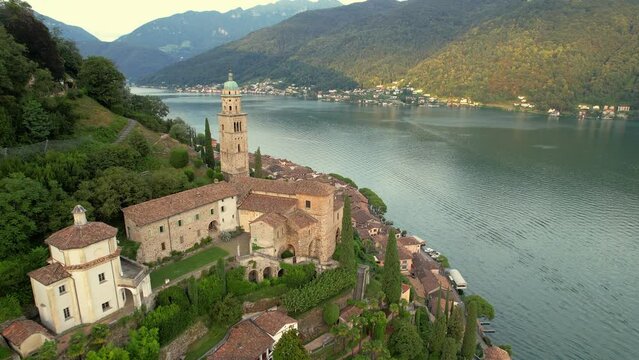 Aerial footage of the parish church Madonna del Sasso stands on the high hill of Vico Morcote, Switzerland. Morcote at the Lake Lugano was once credited as one of the most beautiful Swiss villages.