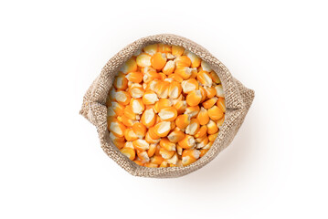 Dry corn seeds in sack bag isolated on white background, top view, flat lay.