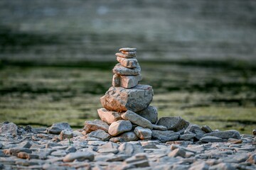 Tranquil landscape featuring a series of stone stacks precariously perched on top of small rocks
