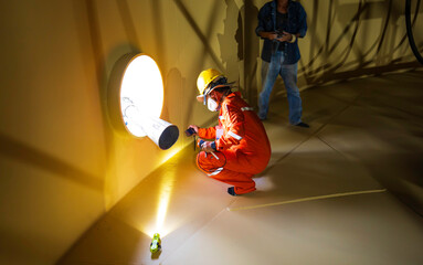 Male worker inspection at a surface painting color test of visual check flashlight record bottom...