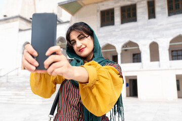 Portrait of smiling young woman taking selfie