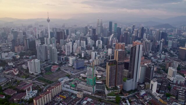 Kuala Lumpur city center with DJI Mavic Drone Loop on beautiful Sunset: 
Petronas Twin Towers, Menara, Warisan, Merdeka skyline panorama, capital of Malaysia