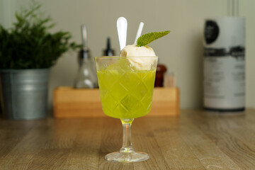 An alcoholic cocktail with a scoop of ice cream on a table