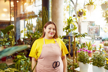 portrait caucasian larger bodied saleswoman in plant shop interior	