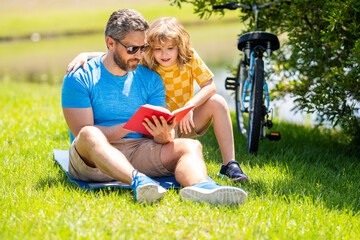 dad and son reading book. dad and son read outdoor. dad and son create literary adventures in...