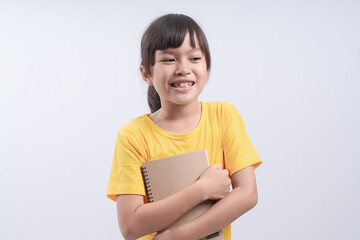 Little beautiful smiling girl holding book, going to school. close up portrait, isolated on white background, childhood. kid hugging a book. lifestyle, interest, hobby, free time, spare time