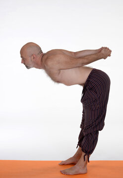 Man doing yoga in photo studio on isolated background.	