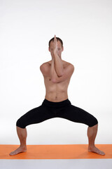 Fototapeta na wymiar Man doing yoga in photo studio on isolated background. 
