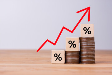 inflation concept, red graph arrow, Percentage sign on a wooden cube with rows of coins in idea for FED considers interest rate hike, world economics, and inflation control, US dollar inflation.
