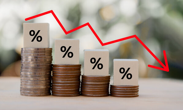 Percentage sign on wooden cubes with Stack of coin bar chart and red graph trending downwards on nature background. Economy recession crisis, inflation, stagflation,business and financial loss concept
