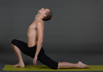 Obraz premium Man doing yoga in photo studio on isolated background. 