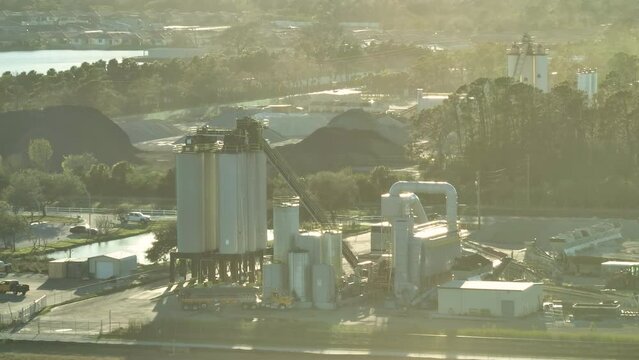 Aerial view of concrete mixing factory at industrial area with cement trucks and heavy building equipment