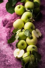 Fresh ripe green apple in purple background.