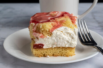 strawberry  square  with a creamy filling and a cup of coffee