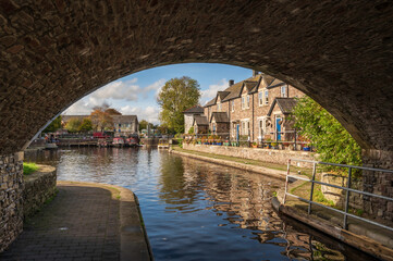 The Monmouthshire and Brecon Canal. View through a stone bridge to the rural buildings beyond, on a sunny autumn day, in Mid Wales