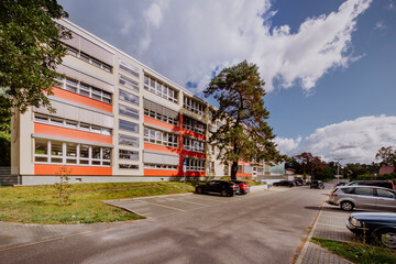 das Vico-von-Bülow Gymnasium mit einem Parplatz vor dem Eingang - obrazy, fototapety, plakaty