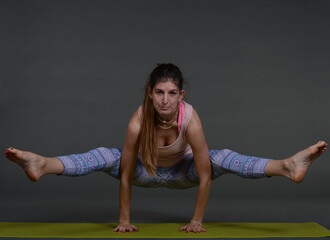 Woman doing yoga in photo studio on isolated background.	
