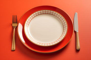 Empty Red plate with knife and fork on red background
