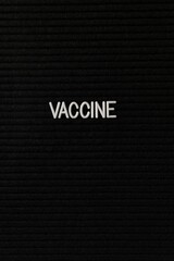 Vertical black spongy board with a text "vaccine" for background