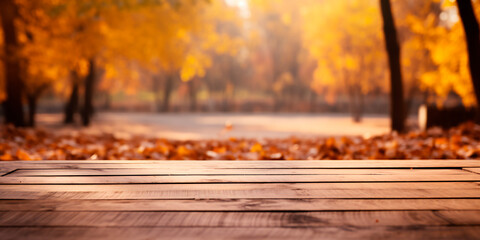 Naklejka na ściany i meble Wooden empty table in front of blurred autumn park and yellow leaves. Platform/table for product demonstration.