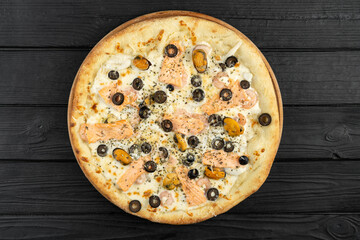 Top view of pizza with seafood and olives on dark wooden background, flat lay