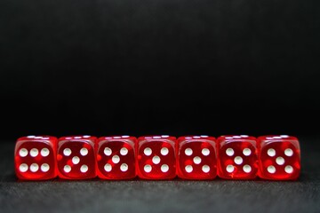 Close up of a line of red dice isolated on a black background