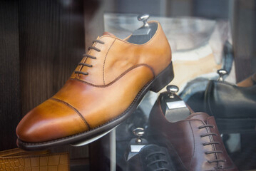 Fototapeta na wymiar Closeup of brown leather shoes for men in a luxury fashion store showroom