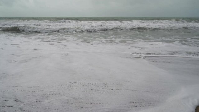 Aerial view of sea waves breaking sandy beach