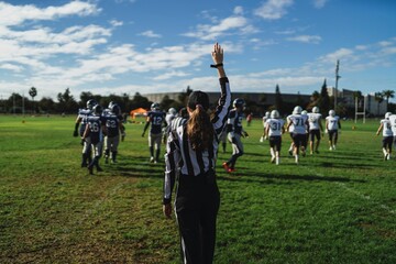 American football referee standing on the field watching the game.