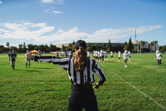 Closeup of an American football referee standing on the field watching the game.