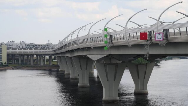 Side view of western high-speed diameter with bridge standing above river water in Saint Petersburg city, Russia. Cloudy sky. Real time video. Urban architecture theme.