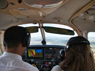 A couple inside the cockpit of an small airplane
