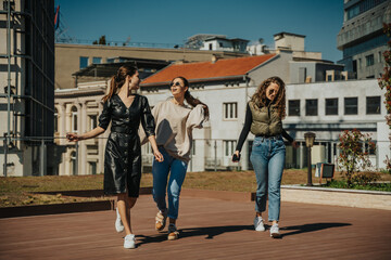 Obraz premium Three beautiful girls hanging out. They are having fun conversation and smiling. Front view shot