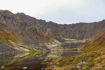 Obraz premium Landscape of a river surrounded by mountains and yellowing trees