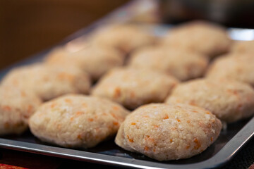 Lots of raw fish cutlets on a tray. Cooking fish burgers